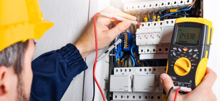 Electrician installing electric cable wires and fuse switch box multimeter.